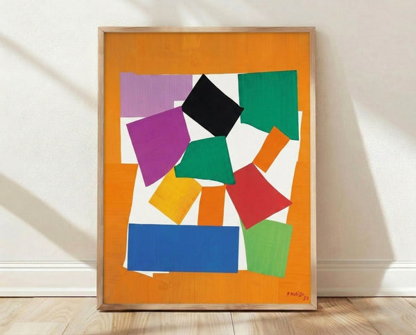 Abstract cut-out poster of The Snail in vibrant geometric shapes of blue, green, orange, and yellow on a neutral background, framed on a wall.