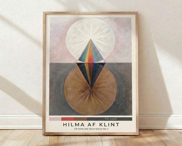 Abstract geometric composition with concentric circles, spirals, and cone shapes in cream, pink, navy blue, and brown tones, framed as a poster on a wall.