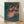 Framed vintage ballet poster featuring three dancers in flowing red costumes, rendered in soft impressionist brushstrokes with warm earth tones and delicate pastel accents.