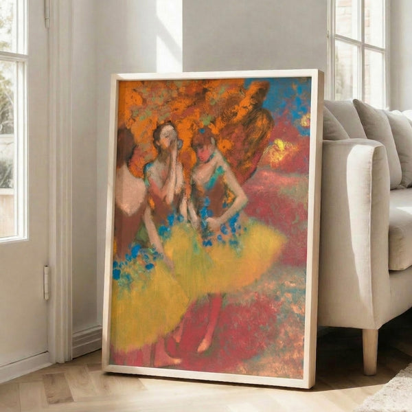 Framed fine art print showing three ballet dancers in yellow garments rendered in classic Impressionist technique with warm palette and atmospheric quality.