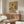 Contemporary abstract painting poster depicting three figures and a disintegrated facial study in a palette of taupe, charcoal, and ochre, hung as wall art.