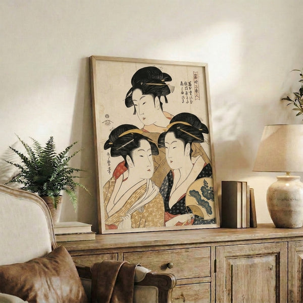 Wall-mounted art print of three refined geisha figures in elaborate kimonos and traditional adornments, combining Japanese woodblock aesthetics with serene elegance in cream and gold hues.