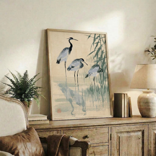 Zen-inspired ink painting of three herons in reedy wetlands, capturing a naturalistic moment in muted cream and sage tones with traditional Japanese woodblock aesthetics.