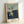 Framed triptych artwork presenting three variations of a solitary male back study in contemporary abstract style, dominated by warm ochre and cool grey tones with cage imagery suggesting confinement.