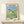 Peaceful Studio Ghibli wall art capturing a magical moment of Totoro in an umbrella-shaded meadow surrounded by children and wildflowers in muted pastels.