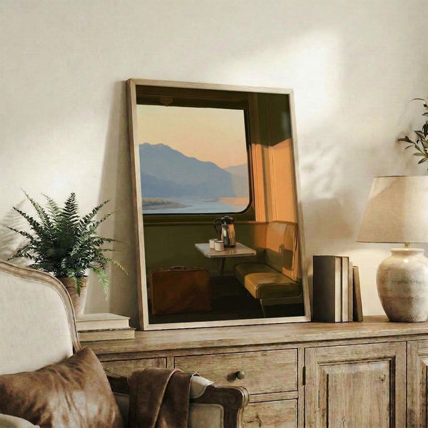 Retro train compartment scene with suitcase and coffee cup on chair, gazing toward mountains and water at dusk in cream, soft blue, and burnt sienna hues; midcentury wanderlust wall art.