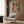 Eclectic boho dining room art featuring crocodiles at a festive table amid tropical plants, fruit arrangements, and candlelight in warm coral and jewel-tone palette.