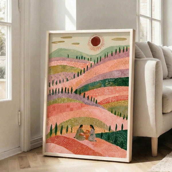 Boho landscape gouache painting on wall showing a serene picnic scene amid rolling terrain and stylized trees under a luminous sunset; soft palette of coral pink, cream, and muted greens conveys tranquil, whimsical charm.
