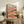 Japandi-inspired gouache landscape poster depicting a pastoral hillside with cypress silhouettes and sun-drenched sky in warm golds and coral pinks; peaceful, romantic mood ideal for cottagecore home decor.