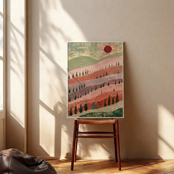 Serene vintage-inspired wall art depicting rolling hills dotted with cypress trees and soft clouds, centered around a glowing sun, in a romantic palette of sage green and coral hues.