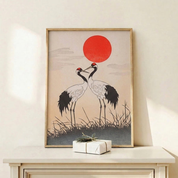 Zen-inspired wall art featuring two cranes in elegant flight, a glowing red sun, and delicate grass elements, rendered in the Japanese woodblock tradition with restrained minimalist color palette.