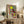 Surrealist wall poster with two abstract figures and a dragonfly rendered in organic shapes and a restrained color scheme of warm and cool tones.