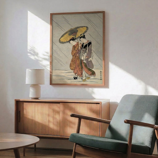 Framed Japanese wall art showing a graceful geisha beneath an umbrella in the rain, executed in traditional woodblock style with soft palette of cream, gold, rust, and olive accents.