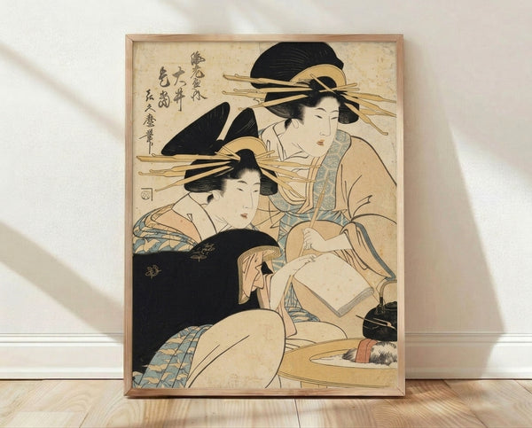 Framed Japanese woodblock print depicting two geishas in kimonos with a kettle, rendered in cream, black, and pale blue tones with gold accents in elegant Edo period style.
