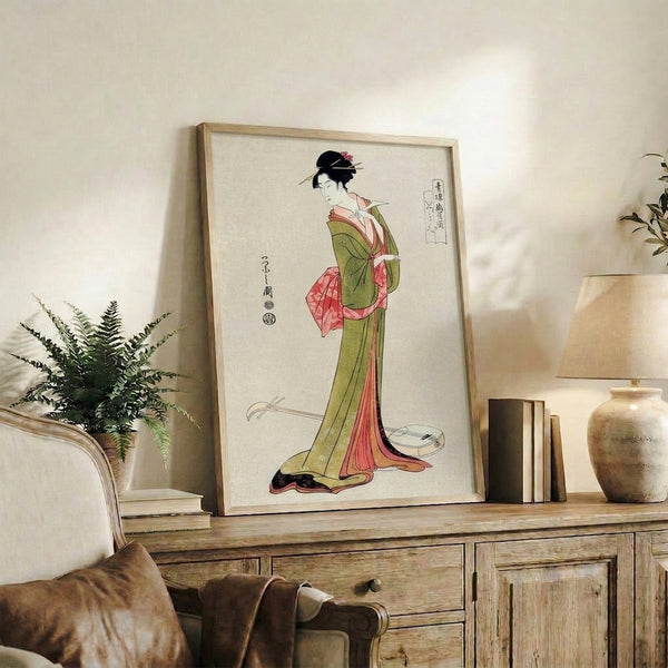Framed artistic print of a geisha in flowing kimono with shamisen, executed in traditional Japanese woodblock style featuring elegant coral, olive, and cream tones with bold black outlines.