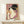 Framed geisha portrait in authentic Japanese woodblock style, showcasing delicate gold detailing and a serene expression against cream and blush tones.
