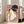 Elegant composition of a kimono-clad geisha holding fan and flowers, executed in traditional woodblock technique with harmonious blush, navy, and gold coloring.