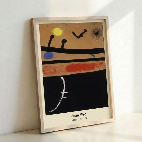 Framed modern art print displaying abstract surrealist figures and symbols in vibrant blue, red, yellow, and black against a clean white ground, radiating playful energy.