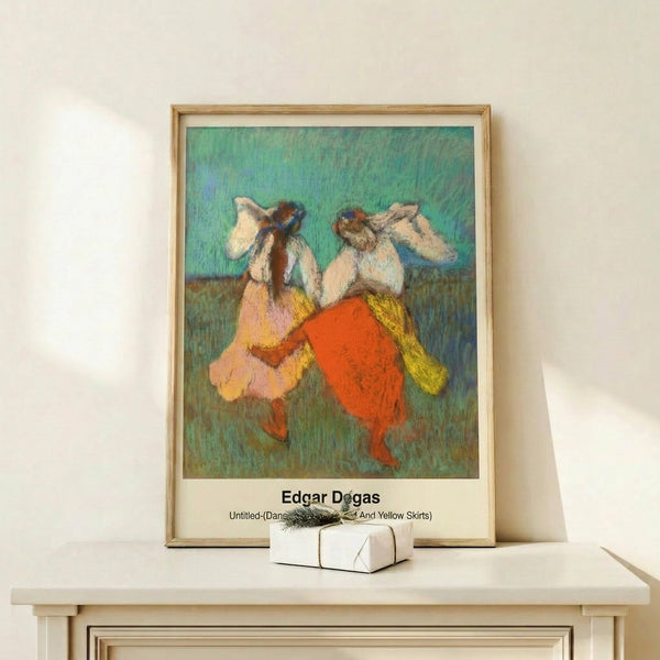 Framed impressionist poster of graceful dancers in bold red and yellow dance skirts, featuring soft blue accents and warm palette, creating elegant home wall art.