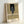 Framed contemporary art print of a solitary figure in shadowy grays and blacks with warm rust accents, conveying isolation and existential tension through abstracted form.