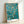Hopeful impressionist framed poster depicting tender almond blossoms in cream and white against a calming teal sky with soft golden and olive accents.