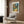 Peaceful outdoor garden art with softly rendered trees and natural pathway in olive green, rust orange, and golden yellow tones.