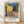 Van Gogh's Cafe Terrace at Night, an Impressionist masterpiece featuring a glowing yellow café with diners on a starlit Parisian street, framed and hung on a wall.
