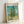 Van Gogh's Cypresses museum print with energetic brushwork in golden yellows and sage greens, tall trees dominating a windswept landscape composition on cream background.