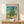Framed vintage landscape artwork featuring cypress trees rendered in characteristic Post-Impressionist style with turquoise and blue swirling sky, contemplative and dynamic.