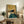 Vintage-style impressionist cat artwork with golden yellow and deep blue tones, showing a playful orange feline with distinctive hat gazing pensively, executed in classic self-portrait composition.