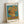 Van Gogh's celebrated sunflower still life painting, with blooming golden flowers in an earthy vase, set against a contemplative blue background in soft ochre and warm hues.