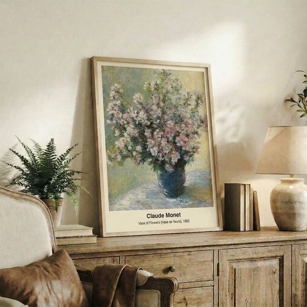 Soft-hued impressionist watercolor print of flowers in a vase, rendered in luminous pinks, lavenders, and creams with delicate green stems and golden light.