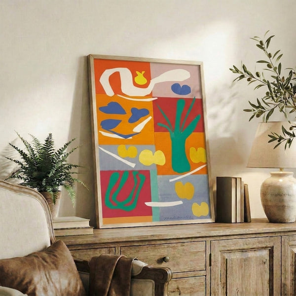 Framed poster with simplified vegetable silhouettes in vibrant hues—a contemporary interpretation of Matisse's celebrated papier-coupée methods.