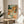 Warm cottagecore-inspired framed art showing a domestic table laden with dim sum dishes, bamboo steamers, and chopsticks in muted sage and terracotta hues.