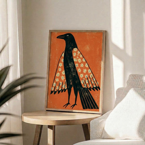 Framed art print of a stylized crow adorned with decorative flowers and botanical patterns in warm oranges and cool teals against a pale yellow background.