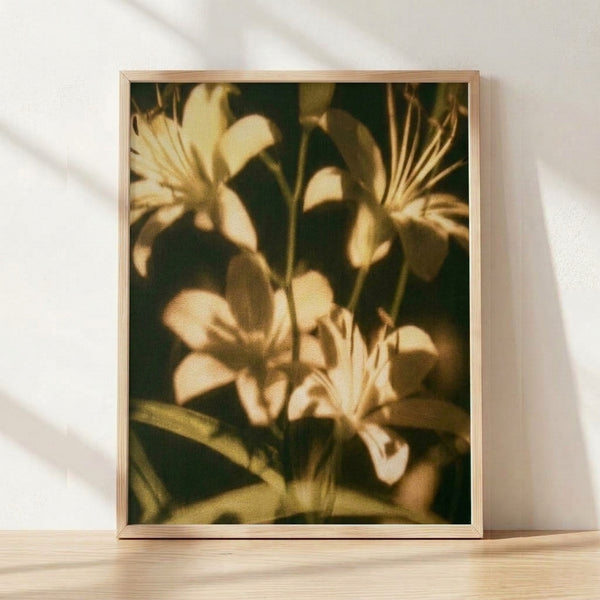 Framed vintage impressionist painting of golden lilies with soft cream and pale yellow petals against dark green foliage, evoking a serene, nostalgic botanical scene.
