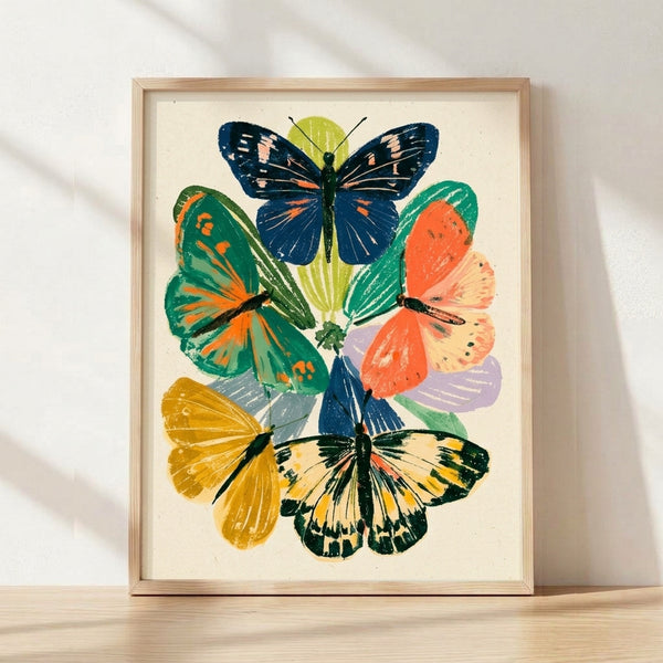 Framed vintage botanical print featuring monarch butterflies perched among delicate flowers and green foliage, rendered in elegant navy, forest green, golden yellow, and coral tones on cream background.