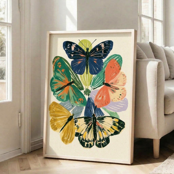 Minimalist naturalist-style illustration of butterflies with blooming plants in a sophisticated palette of deep blue, sage green, warm gold, and soft coral hues displayed as framed wall art.