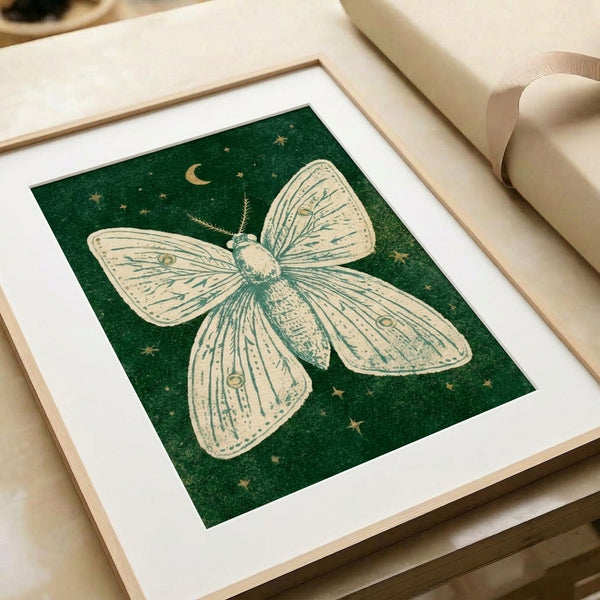 Minimalist framed artwork depicting a luna moth under moonlight with gold accents and teal details, evoking a calm, dreamy nocturnal mood in soft earthy and celestial hues.