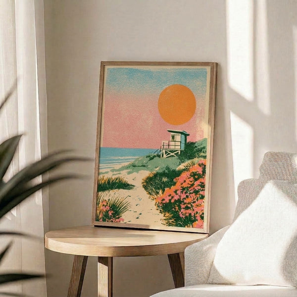 Retro beach scene art print showing a serene sunset with warm orange and pink hues, lifeguard station, ocean waves, and coastal vegetation in muted sage and teal colors.