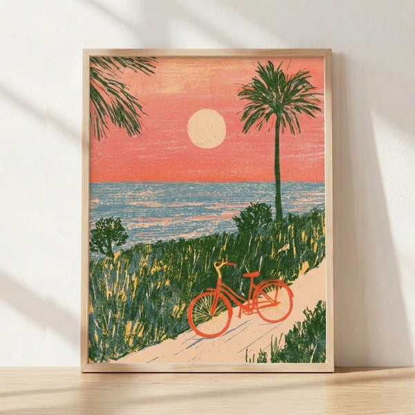 Vintage-style framed poster art depicting a bicycle resting on a sandy beach at sunset, with palm trees, ocean waves, and warm coral and teal tones creating a nostalgic, serene coastal scene.