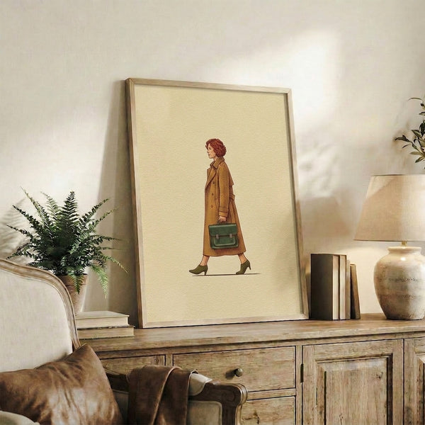 Framed vintage-style poster displaying a woman in 1970s fashion—coat, boots, and structured bag—rendered as elegant line art in muted earth-tone colors.