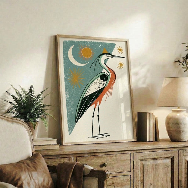 Framed vintage-style bird poster showcasing a graceful heron amid stars, moon, and sun symbols in nostalgic cream, teal, and rust-orange palette.