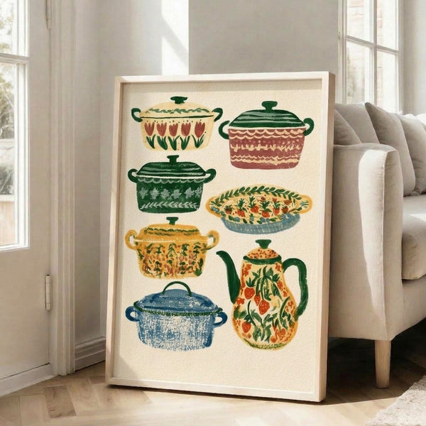 Nostalgic cottagecore kitchen illustration with stylized cookware and florals in warm golden yellow, slate blue, and cream; folk art framed print displayed on wall.