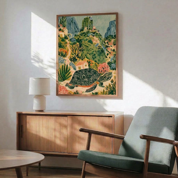 Folk art framed poster showcasing a peaceful Mediterranean scene with a tortoise amid rolling hills, cream cottages, and lush olive vegetation rendered in soft golden and slate blue tones.
