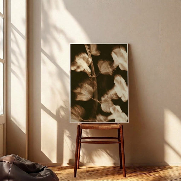 Dreamy vintage botanical poster in muted sepia palette showing softly rendered flower petals and leafy stems, displayed framed with a timeless watercolor-inspired appearance.