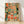 Retro folk art print of a bustling market street scene with people, books, and vendors in warm orange, teal, red, and forest green tones, evoking nostalgic community spirit.