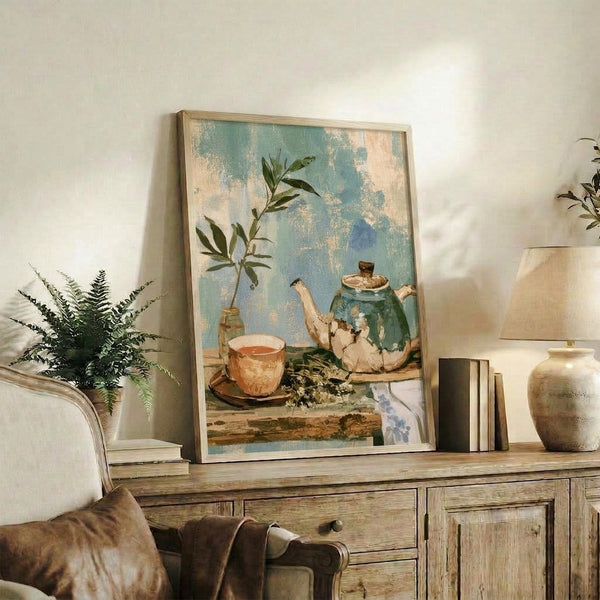 Japandi-style watercolor art print featuring a serene tea still life with a textured teapot, ceramic cup, blooming flowers, and greenery in muted blues, beiges, and sage tones framed on a wall.
