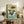 Vintage-style framed poster of a whimsical whale breaching the sea with a miniature bonsai tree on its back, rendered in nostalgic gold, teal, and coral hues with clouds and birds.