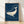 Minimalist line art poster of a whale swimming beneath a crescent moon and stars in a deep navy night sky, with gold accents and cream details.